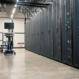 Rows of server racks in a data center with a polished concrete floor
