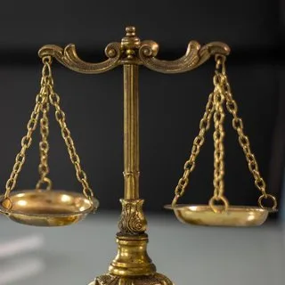 Brass scales of justice on a dark background